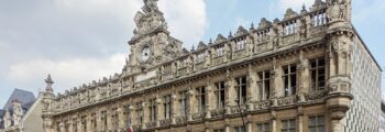 location de jet privé : Cathédrale gothique, arbres et ciel nuageux.
